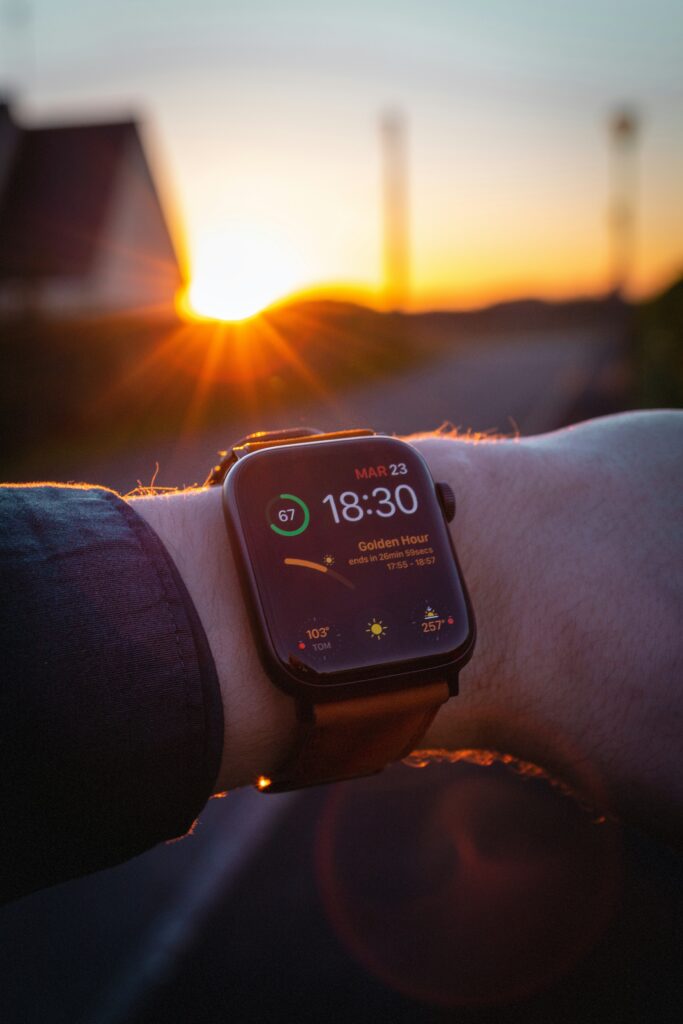 Person looking at apple watch while while theres a sunset